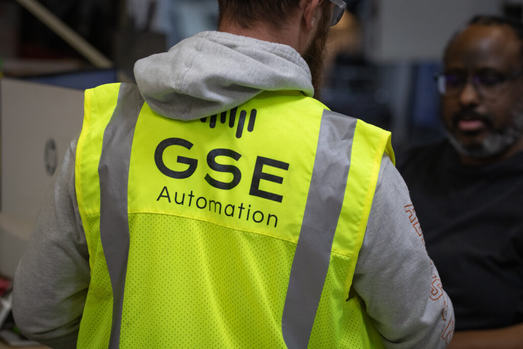 Man wearing bright yellow vest with "GSE Automation" written on the back